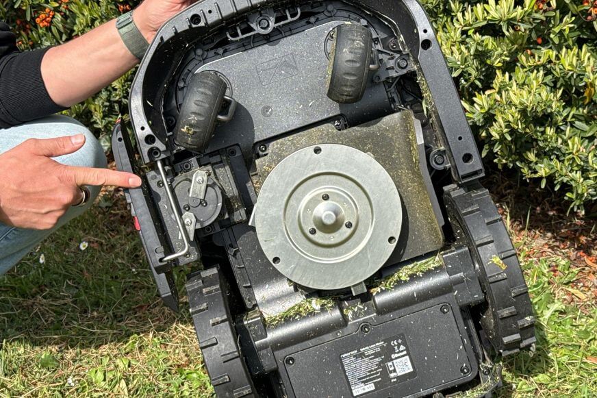 Roborock RockMow S1 wird von unten gezeigt und man sieht die Mährscheibe, Klingen und Randschneidemodul